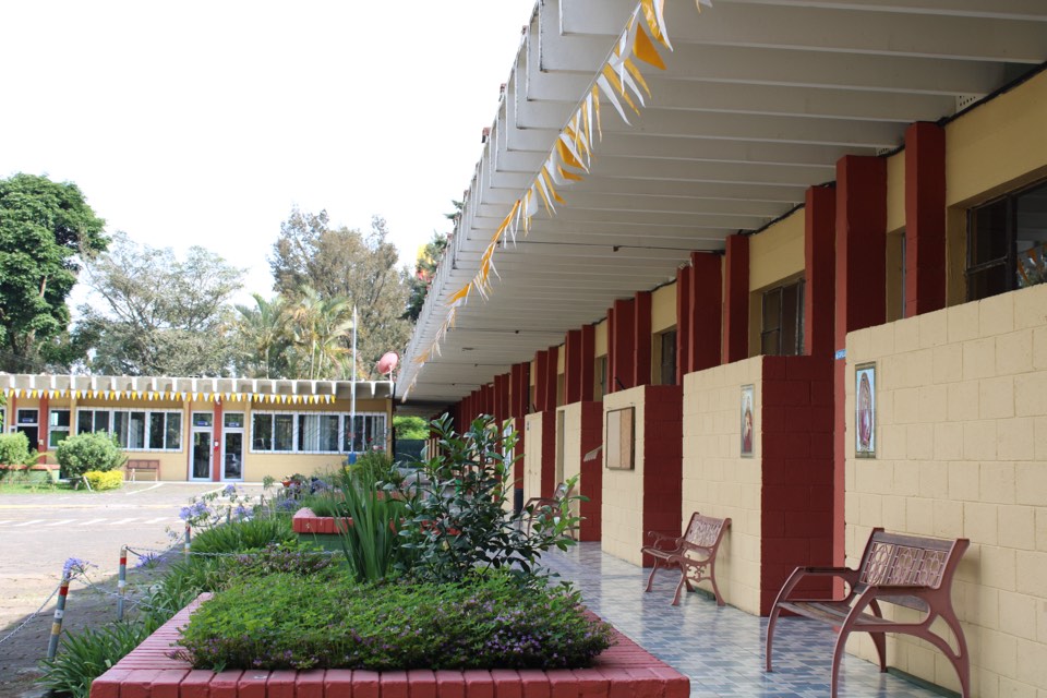 Corredor techado con bancas junto a las aulas